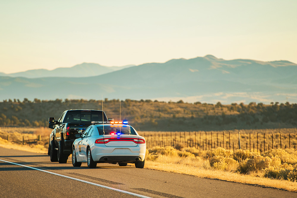 Police cruiser conducting a roadside traffic stop on highway shoulder – defense for load securement violations in Michigan