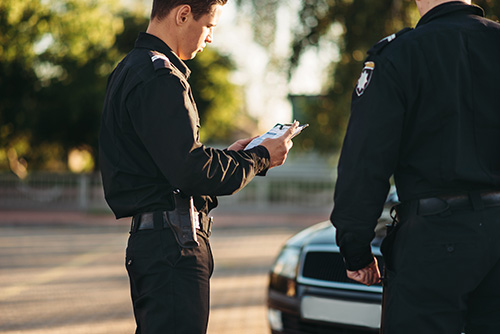 Police officer writing a speeding ticket in Southeast Michigan service areas